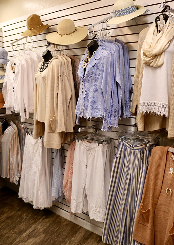 wall of blouses and ladies hats